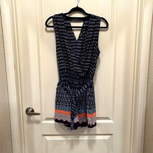 Sleeveless tie waist Aztec style print V-neck romper with pockets & button back.